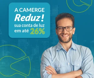 Homem sorridente de óculos e camisa azul clara com braços cruzados, ao lado de um banner que diz "A CAMERGE Reduz! sua conta de luz em até 26%"
